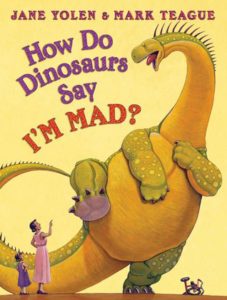 The cover of the book How Do Dinosaurs Say I'm Mad? The illustration is of an angry long-necked dinosaur lifting up its foot next to a crushed bicycle while an adult and child scold it.