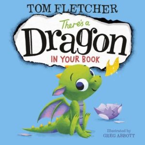 The cover of the book There's a Dragon in Your Book. The illustration is of a cute green dragon blowing a flame out of its nose in front of the eggshell it just exited. The blue background is made to look like a hole was burned out of the middle, which is where the title is.