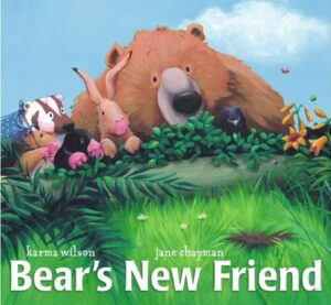 The cover of the book Bear's New Friend. The illustration is of bear and several other woodland animals looking at a brown patch in the grass. 